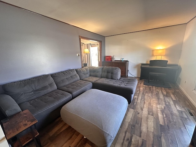 living area with visible vents, baseboards, and wood finished floors