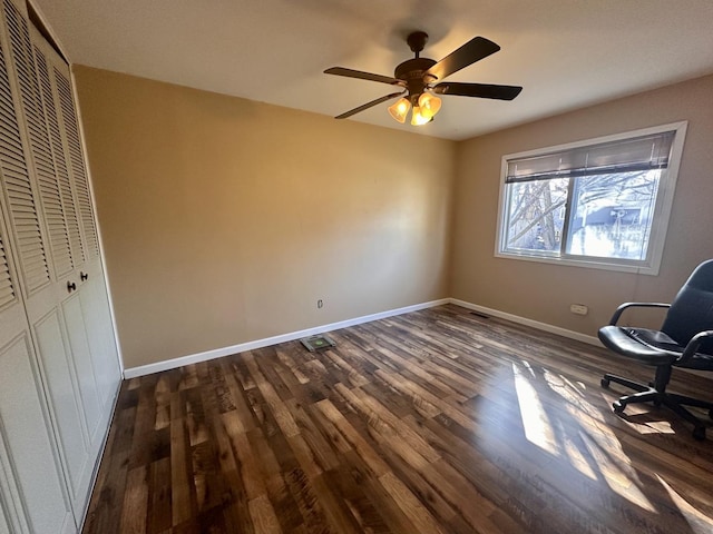 interior space featuring baseboards, dark wood-type flooring, and a ceiling fan