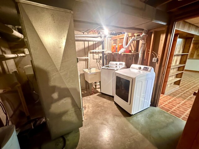 clothes washing area with a sink, independent washer and dryer, and laundry area