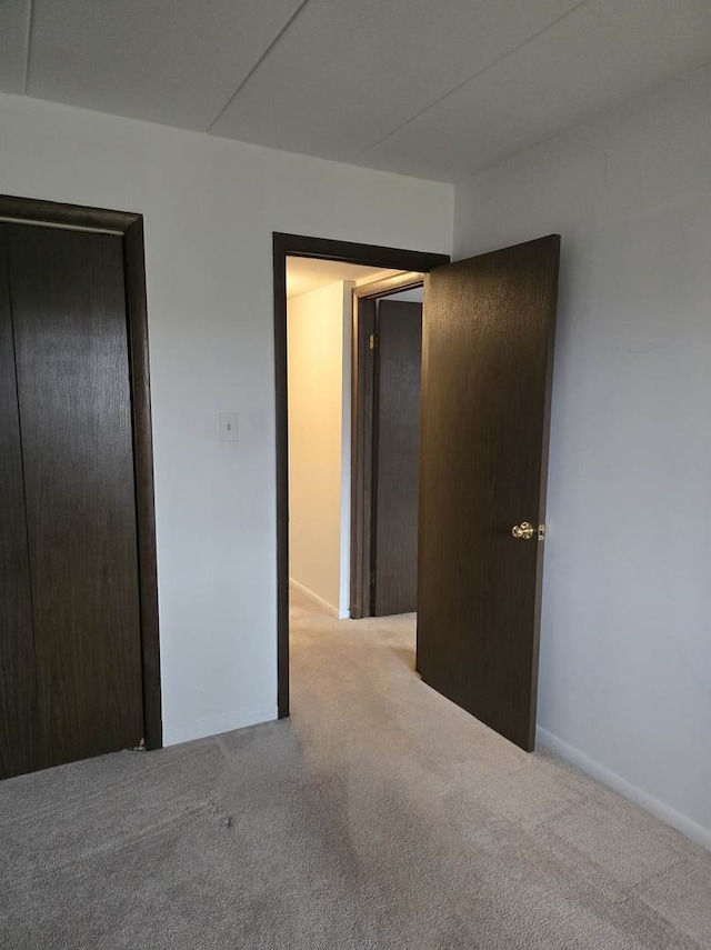 unfurnished bedroom featuring carpet flooring and baseboards