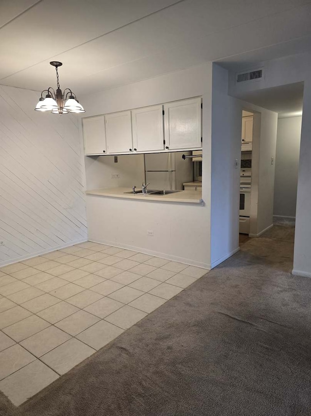 interior space featuring visible vents, light carpet, a sink, light tile patterned floors, and a chandelier