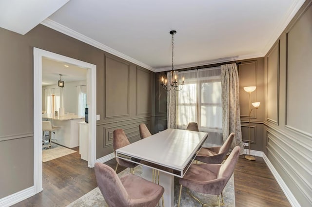 dining area featuring crown molding, a decorative wall, a notable chandelier, and dark wood-style floors