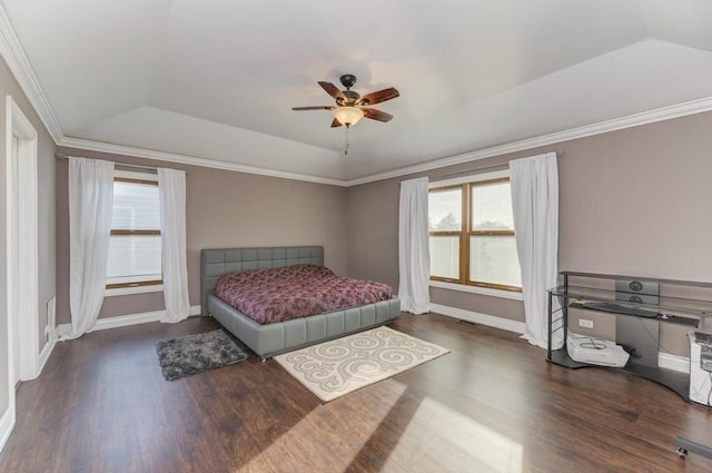 bedroom with dark wood finished floors, a raised ceiling, baseboards, and ornamental molding