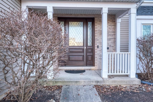 view of exterior entry featuring brick siding