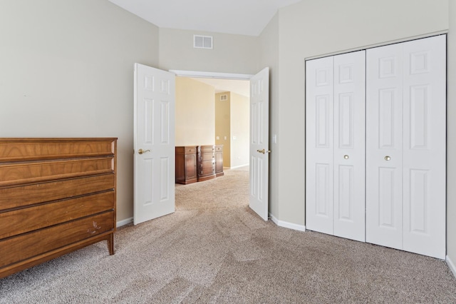 unfurnished bedroom with a closet, baseboards, visible vents, and carpet floors