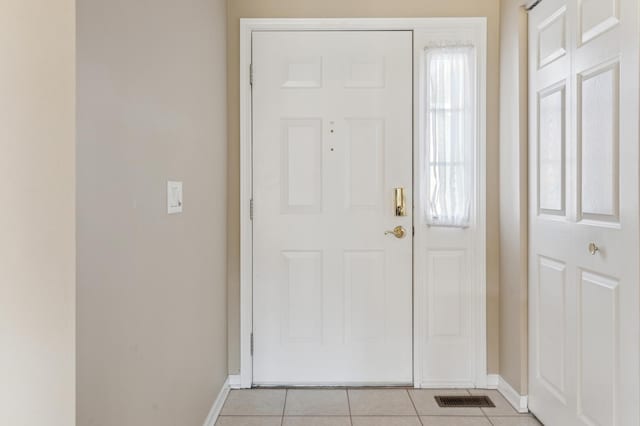 foyer featuring light tile patterned floors, visible vents, and baseboards