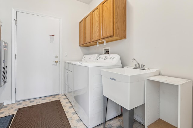 laundry room featuring cabinet space, independent washer and dryer, light floors, and a sink