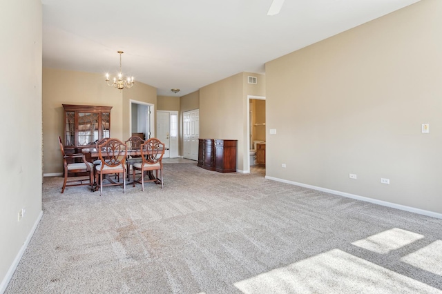 carpeted dining space featuring a notable chandelier, baseboards, and visible vents