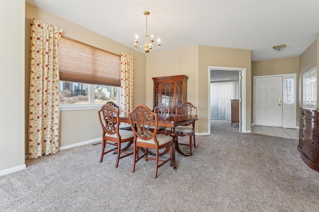 carpeted dining room with baseboards and a chandelier