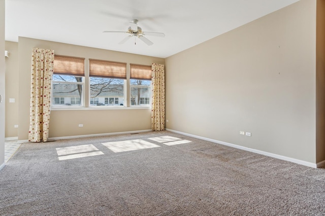 carpeted spare room with baseboards and ceiling fan