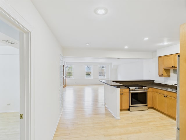 kitchen with dark countertops, a sink, electric stove, a peninsula, and light wood-type flooring