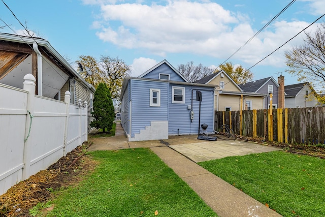 back of property featuring a yard, a patio area, and fence