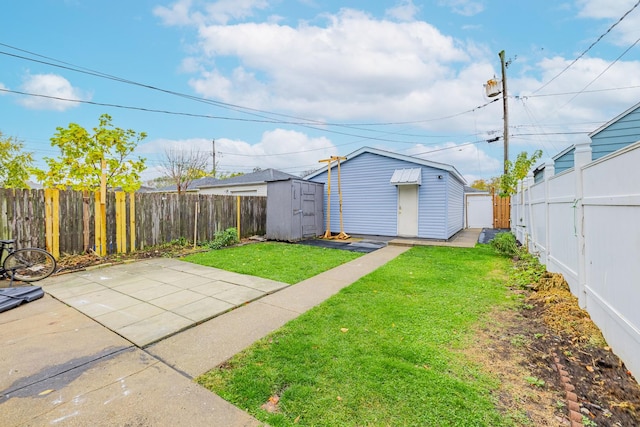 view of yard featuring a storage unit, an outbuilding, a fenced backyard, and a patio area