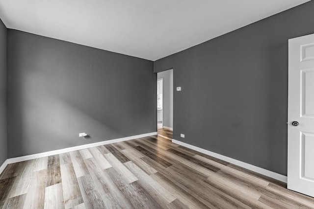 unfurnished room featuring baseboards and wood finished floors