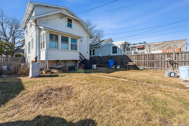 back of house with a lawn and fence