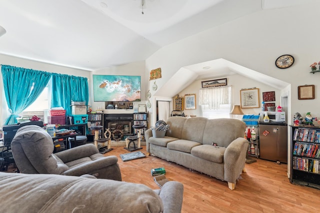 living room featuring wood finished floors and vaulted ceiling