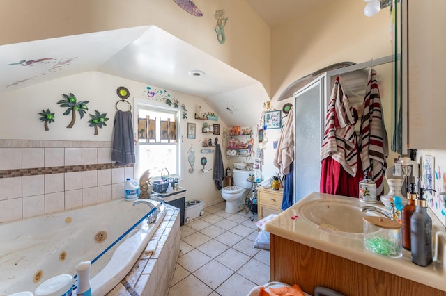 full bathroom featuring vanity, a whirlpool tub, vaulted ceiling, tile patterned floors, and toilet