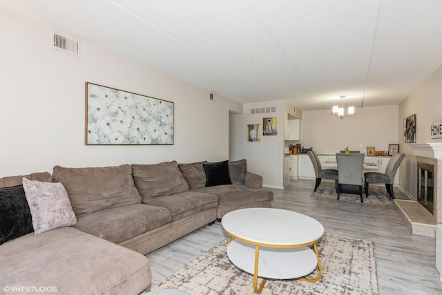 505 Redondo Dr Unit 311, Downers Grove, IL 60516 - living room with a notable chandelier, visible vents, baseboards, and light wood-style floors