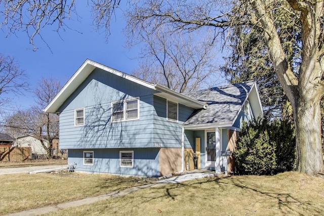 exterior space featuring a yard and roof with shingles