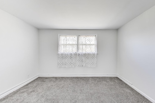 unfurnished room featuring baseboards and carpet floors