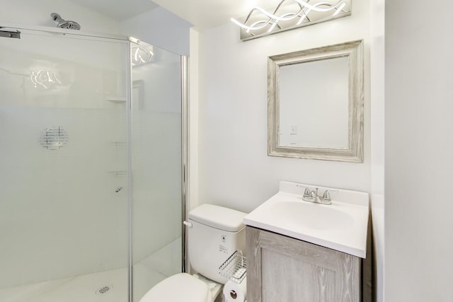 bathroom featuring toilet, a stall shower, and vanity