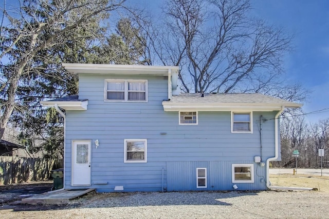 back of property featuring fence and roof with shingles