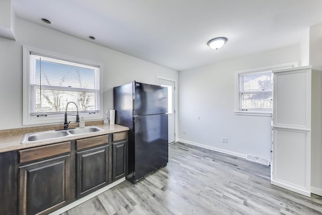 kitchen with visible vents, plenty of natural light, freestanding refrigerator, and a sink