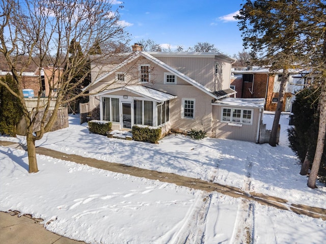 snow covered house with a sunroom