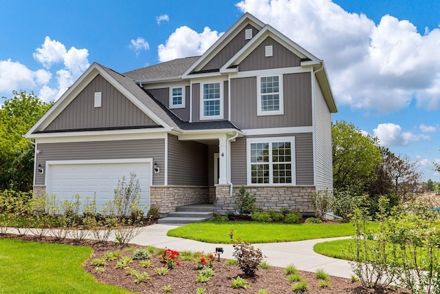 craftsman house featuring board and batten siding, a shingled roof, a front yard, a garage, and stone siding