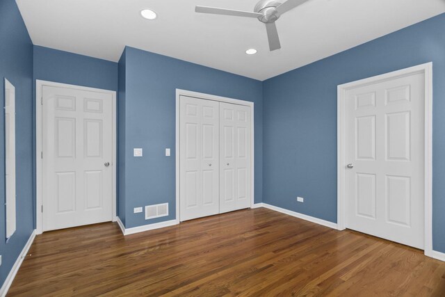 unfurnished room with wood finished floors, visible vents, and baseboards