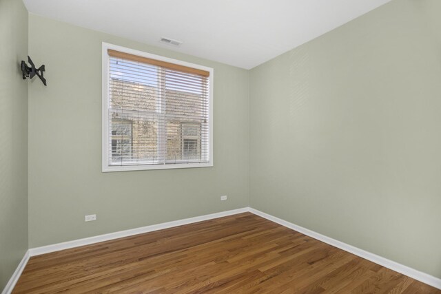 unfurnished bedroom featuring visible vents, baseboards, a closet, and dark wood finished floors