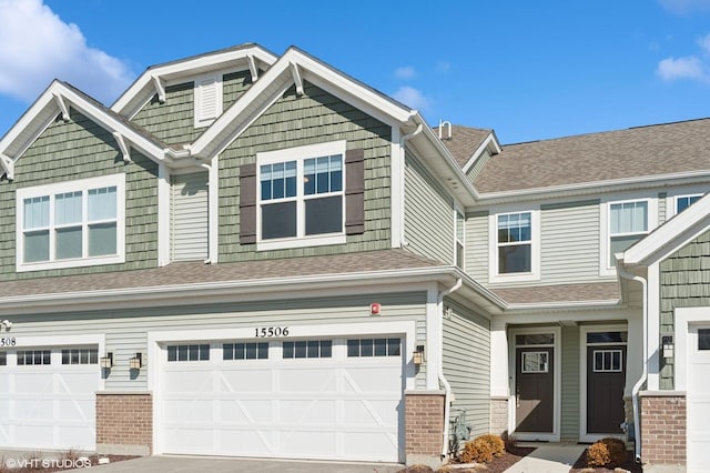 view of front facade with a garage, driveway, and a shingled roof