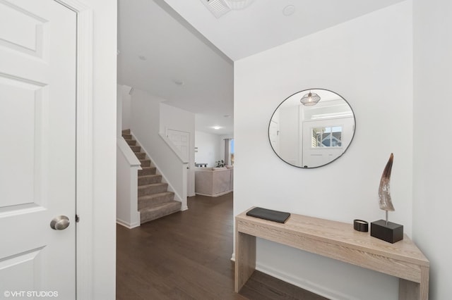 hall featuring stairs, dark wood finished floors, and visible vents