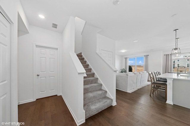 stairway featuring recessed lighting, visible vents, baseboards, and wood finished floors