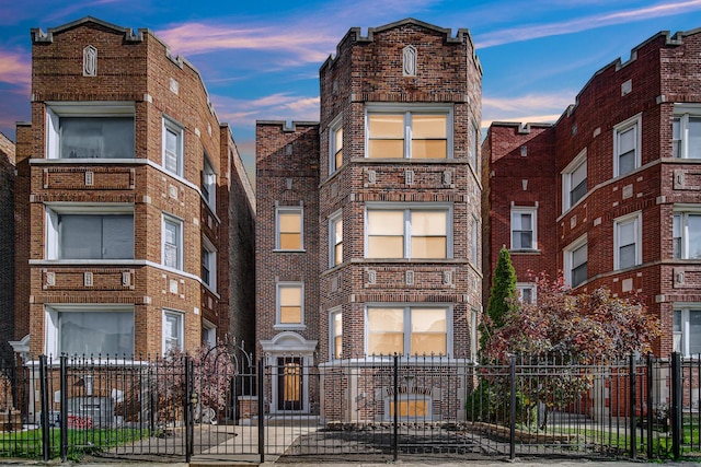 view of front facade with brick siding and a fenced front yard