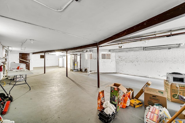 unfinished basement featuring heating unit and water heater