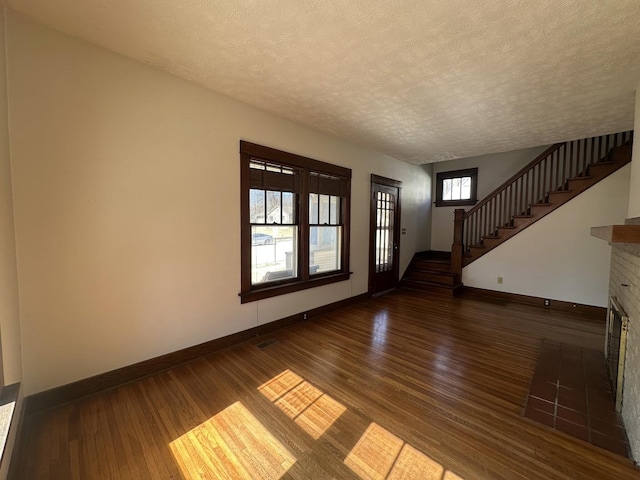 interior space featuring stairs, wood finished floors, a fireplace, and baseboards