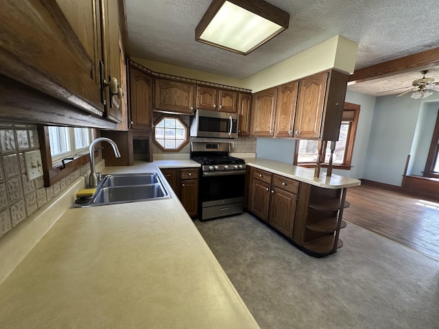 kitchen with a sink, open shelves, appliances with stainless steel finishes, and light countertops