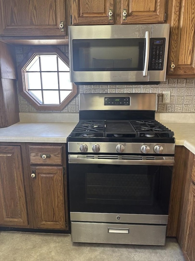 kitchen featuring stainless steel appliances, backsplash, and light countertops