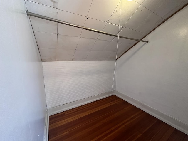 additional living space with dark wood finished floors and baseboards