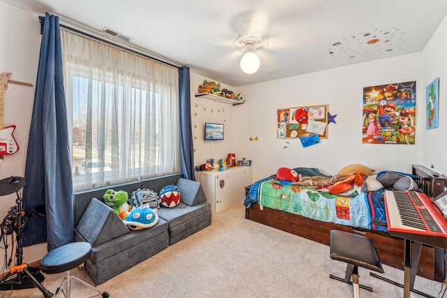 carpeted bedroom featuring a ceiling fan and visible vents