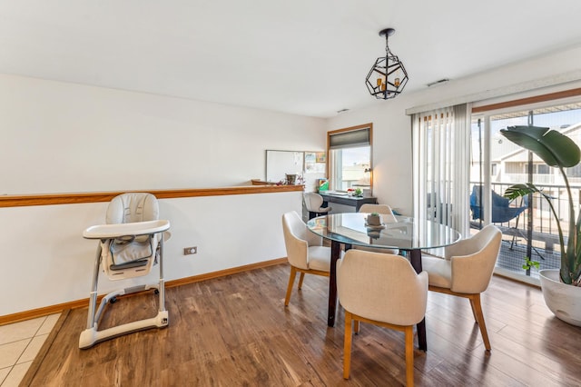 dining room featuring visible vents, wood finished floors, and baseboards