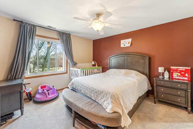 carpeted bedroom with visible vents, baseboards, and ceiling fan