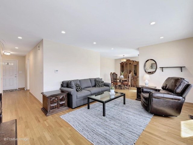 living room with recessed lighting, light wood-type flooring, and baseboards