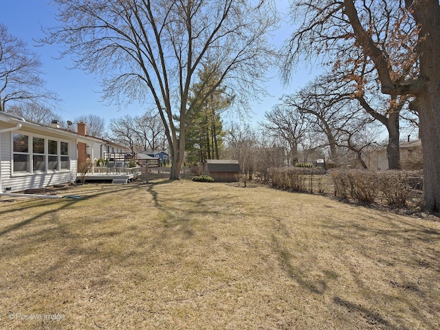 view of yard with an outdoor structure, a shed, and a wooden deck