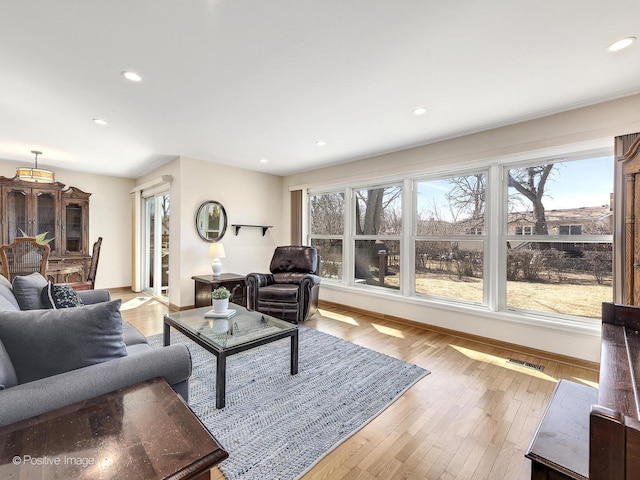 living room featuring hardwood / wood-style flooring, recessed lighting, baseboards, and visible vents