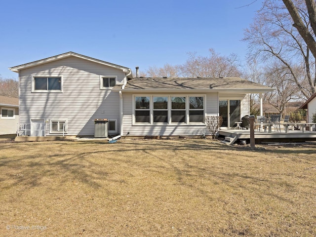 rear view of house with a yard and a wooden deck