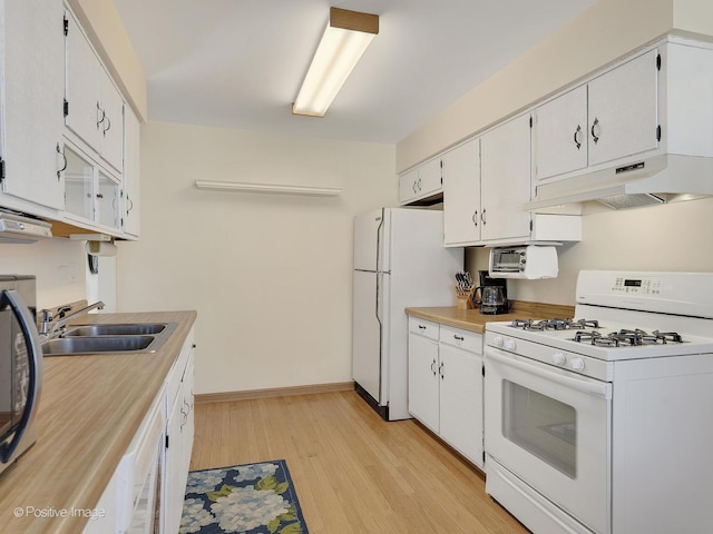 kitchen featuring under cabinet range hood, white appliances, white cabinetry, and a sink