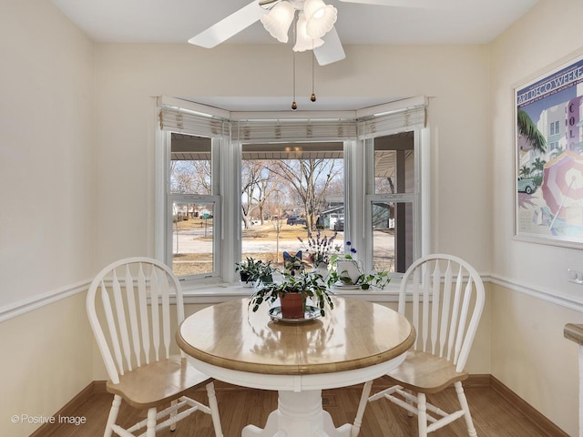 dining room featuring ceiling fan, baseboards, and wood finished floors