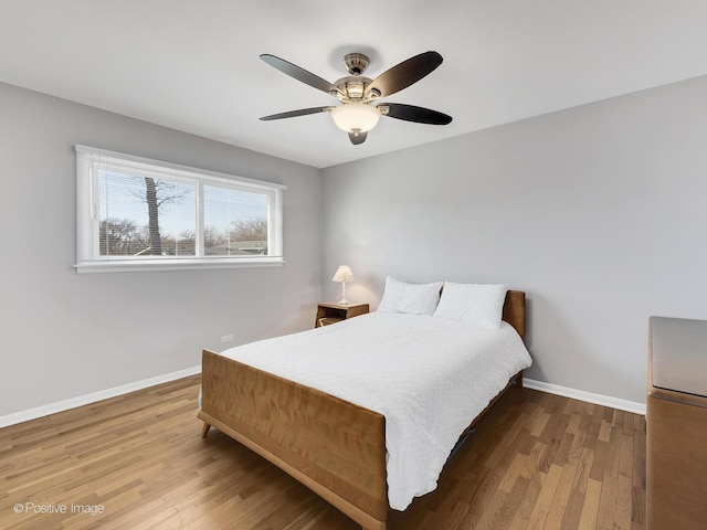 bedroom featuring ceiling fan, baseboards, and wood finished floors